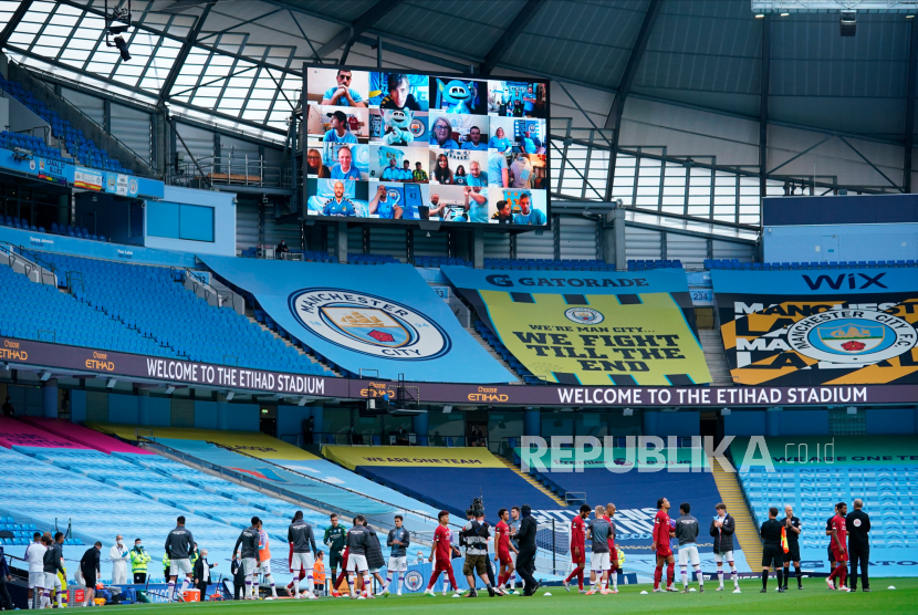 Manchester city supporters watch on the big screen as Liverpool players receive a guard of honour from Manchester City players as they enter the pitch for their English Premier League soccer match at Etihad Stadium in Manchester, 02 July 2020.  