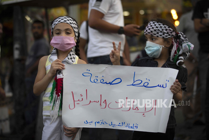 Gadis-gadis Palestina memegang tanda bertuliskan, Ganggu kesepakatan antara Uni Emirat Arab dan Israel, selama protes terhadap normalisasi hubungan antara Uni Emirat Arab dan Bahrain dengan Israel, di kota Ramallah, Tepi Barat, Selasa, September. 15, 2020. 