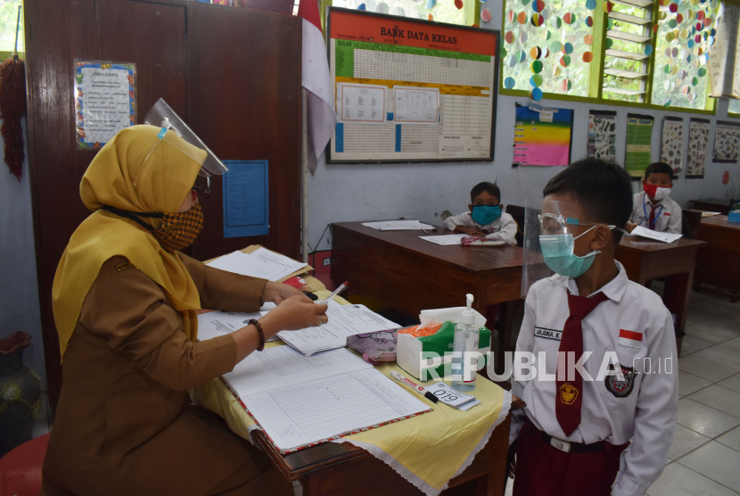 Murid SD mengikuti simulasi belajar tatap muka dengan menerapkan protokol kesehatan pencegahan penularan COVID-19 di SDN 1 Kare, Kabupaten Madiun, Jawa Timur, Senin (14/12/2020). Simulasi tersebut sebagai persiapan pelaksanaan belajar secara tatap muka pada masa pandemi COVID-19 yang akan dimulai 4 Januari 2021. 