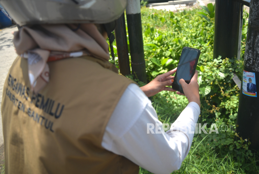 Petugas Pengawas Pemilu memotret pelanggaran pemasangan alat peraga kampanye (APK). Presiden Jokowi menaikkan tunjangan pegawai di lingkungan Bawaslu per 12 Februari.