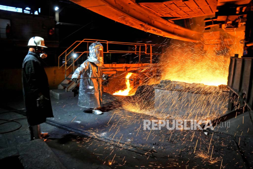 Seorang pekerja berjas pelindung menyodok batang logam untuk menyadap terak dari tungku peleburan di pabrik pengolahan nikel PT Vale Indonesia di Sorowako, Sulawesi Selatan, Indonesia.