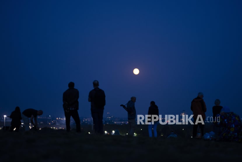 Orang-orang melihat fenomena alam supermoon.