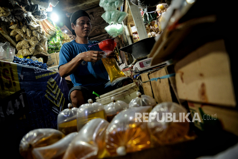 Pedagang mengemas minyak curah di lapaknya. Pembeli minyak goreng curah di Pasar Terong Makassar lebih memilih gunakan KTP daripada aplikasi. Ilustrasi.
