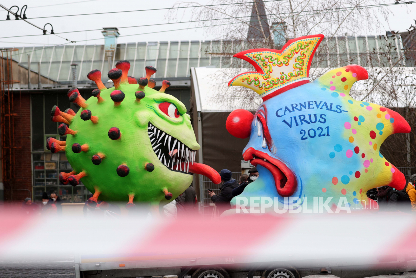 Jerman Perpanjang Karantina Hingga 28 Maret. Kendaraan hias karnaval yang menggambarkan virus corona yang menyeringai suram (kiri) dan virus karnaval menangis sedih (kanan) disiapkan pada Rose Monday di Duesseldorf, Jerman, 15 Februari 2020. 
