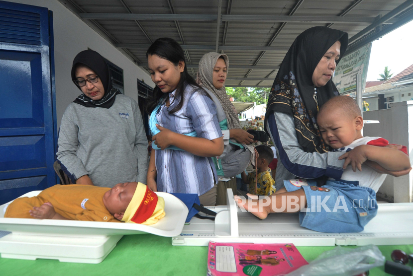 Kader posyandu menimbang berat anak saat kegiatan posyandu di Kecamatan Ratu Agung, Kota Bengkulu, Bengkulu, Sabtu (24/2/2024). Pemerintah menargetkan penurunan prevalensi stunting secara nasional dari 21,6 persen pada pertengahan tahun 2023 turun menjadi 14 persen di tahun 2024. 