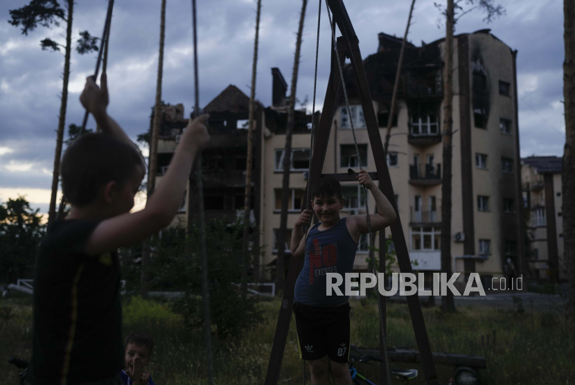 Anak-anak bermain di dekat gedung yang hancur selama serangan di Irpin, di pinggiran Kyiv, Ukraina, Minggu, 12 Juni 2022. Dana Anak-Anak Perserikatan Bangsa-Bangsa (UNICEF) mengatakan, perang Ukraina-Rusia dan meningkatnya inflasi telah menyebabkan 4 juta anak di seluruh Eropa timur dan Asia Tengah jatuh ke dalam jurang kemiskinan.