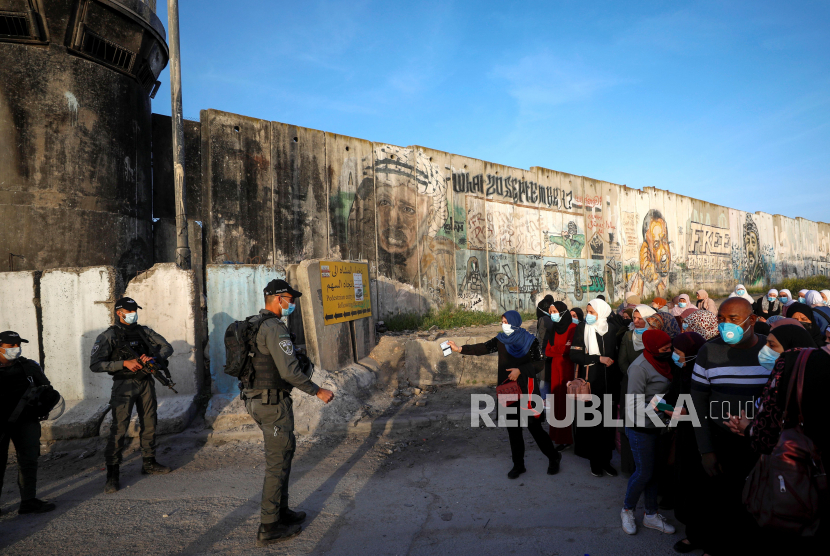 Warga Palestina mengantre di pos pemeriksaan Israel untuk bisa pergi menuju Kompleks Masjid Al Aqsa dekat Ramalla Tepi Barat, Palestina, Jumat (16/4).
