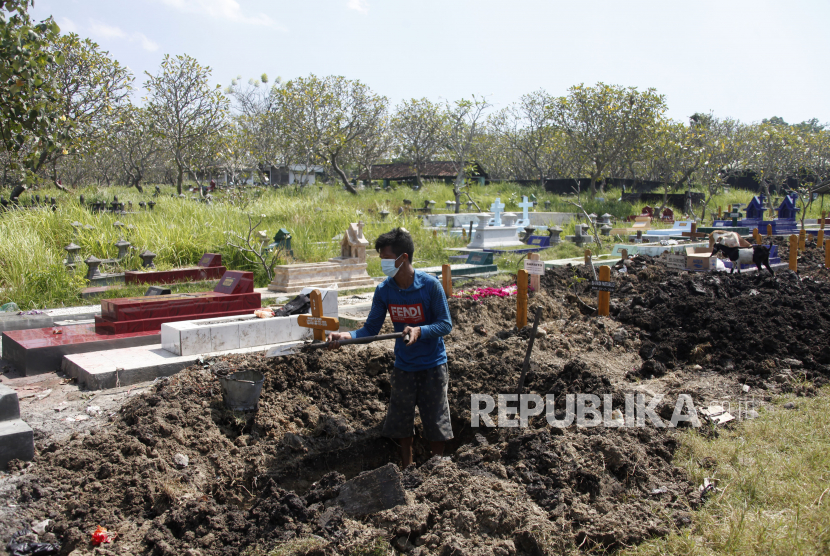 Petugas menyiapkan lubang untuk pemakaman jenazah pasien Covid-19 di Tempat Pemakaman Umum (TPU) Purwoloyo, Solo, Jawa Tengah, Ahad (11/7/2021). Seorang anak berusia delapan tahun di Sukoharjo menjadi yatim piatu setelah ayah dan ibunya meninggal akibat Covid-19 pada pekan lalu.