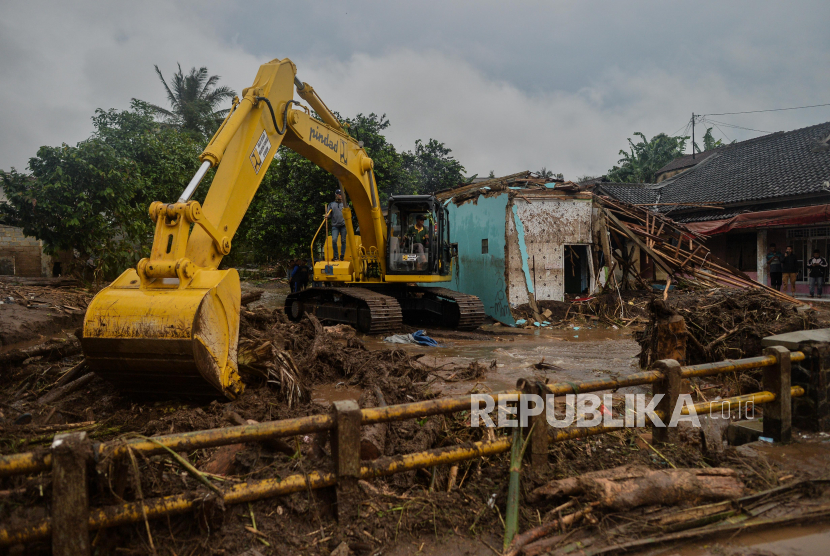 Alat berat membersihkan material lumpur yang akibat banjir bandang di Kampung Cibuntu, Desa Pasawahan, Kecamatan Cicurug, Kabupaten Sukabumi, Jawa Barat, Selasa (22/9). Banjir bandang tersebut terjadi pada Senin (21/9) pukul 17.00 WIB akibat luapan sungai Citarik-Cipeuncit yang merendam tiga kecamatan yakni Cicurug, Parungkuda, Cidahu dan menyebabkan 234 rumah rusak, 210 kepala keluarga mengungsi serta tiga orang meninggal dunia. Republika/Thoudy Badai