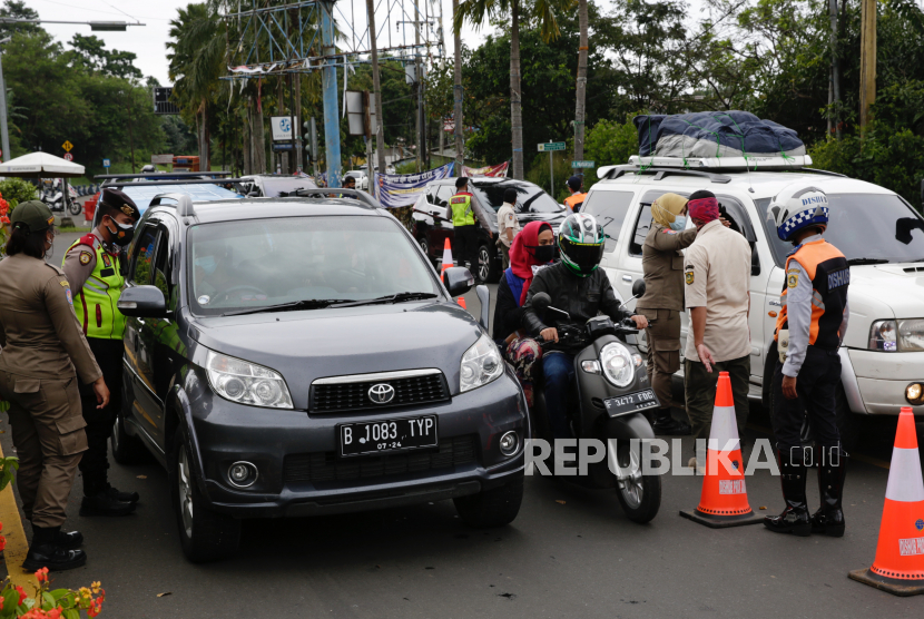  Polisi dan petugas keamanan Indonesia menghentikan pengendara untuk memeriksa surat kesehatan dan dokumen mereka selama pemeriksaan keamanan di Puncak Bogor, Indonesia, 31 Desember 2020. Menurut angka terbaru, Indonesia telah mencatat lebih dari tujuh ratus ribu kasus penyakit virus korona (COVID-19) Sejak dimulainya pandemi. 