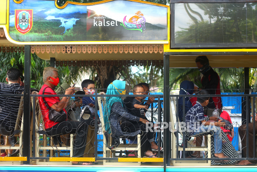 Wisatawan menaiki bus untuk berkeliling kota di Kawasan Tugu 0 Km, Banjarmasin, Kalimantan Selatan, Ahad (25/10/2020). Indonesia Halal Tourism Summit (IHTS) 2020 dilaksanakan pekan lalu berupaya mendorong pariwisata halal Indonesia.. 