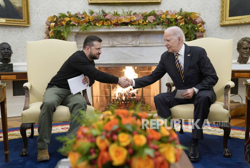  Presiden Joe Biden berjabat tangan dengan Presiden Ukraina Volodymyr Zelenskyy saat mereka bertemu di Ruang Oval Gedung Putih, Selasa, (12/12/2023), di Washington.
