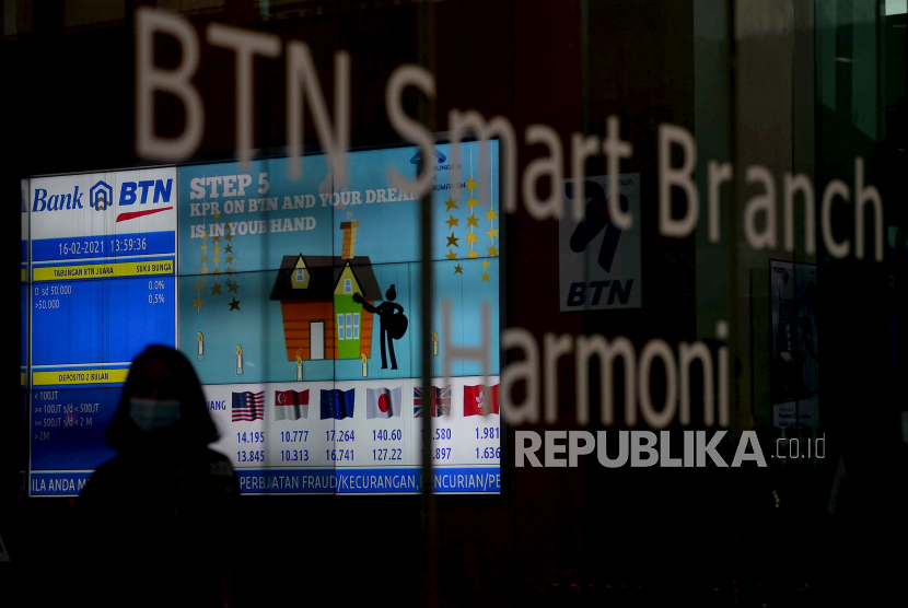 Nasabah melintas didepan layar elektronik yang menampilkan informasi pembiayaan rumah di BTN Smart Branch Harmoni, Jakarta, Selasa (16/2). PT Bank Tabungan Negara (Persero) Tbk akan memperkuat permodalan lewat right issue. 