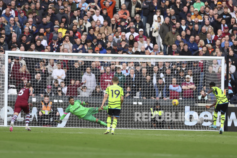 Penyerang Arsenal Bukayo Saka (kanan) mencetak gol kedua timnya ke gawang West Ham United lewat titik putih dalam lanjutan Liga Primer Inggris di Stadion London, Ahad (11/2/2024).
