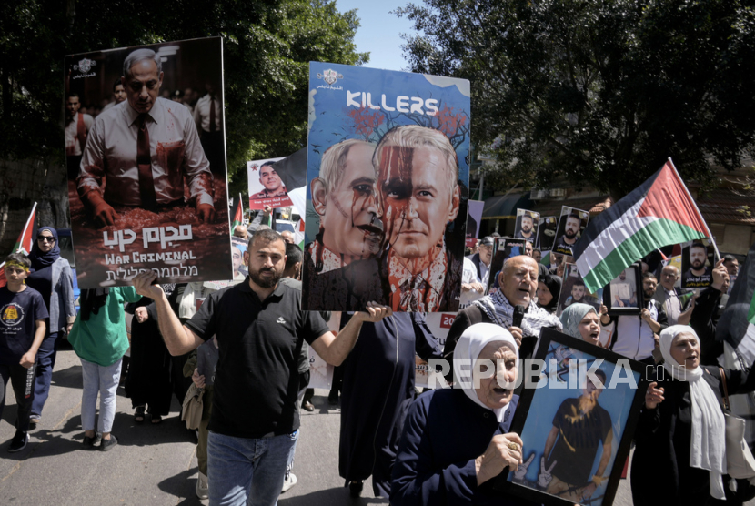 Pengunjuk rasa membawa poster PM Israel Benjamin Netanyahu. ICC berencana akan melakukan penanahan atas Netanyahu 