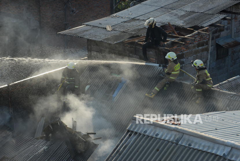 Petugas Penanggulangan Kebakaran dan Penyelamatan (Gulkarmat) bersama warga memadamkan api yang membakar pemukiman warga di Jalan Anyer 15 RT 6 RW 9, Menteng, Jakarta Pusat, Jumat (29/9/2023).