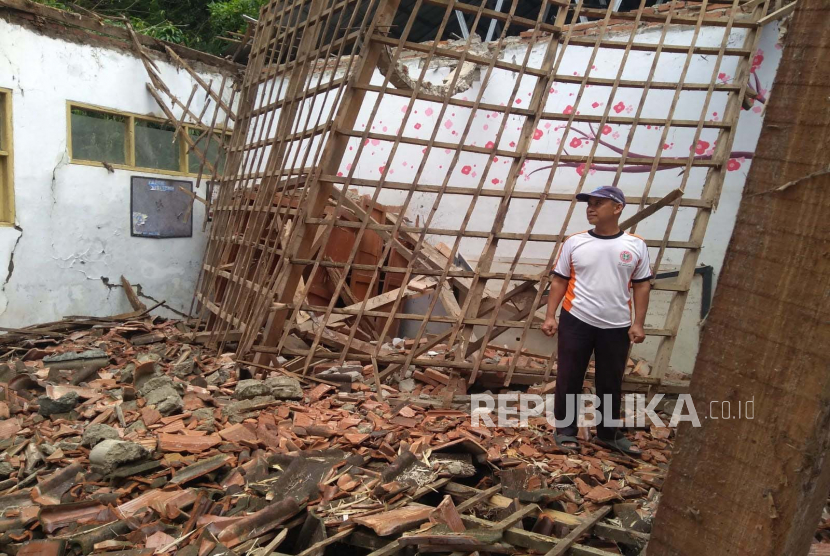 Seorang guru menunjukkan kondisi ruang kelas yang atapnya ambruk di SDN 3 Sukagumiwang, Kabupaten Indramayu, Jawa Barat, Rabu (1/3/2023). 