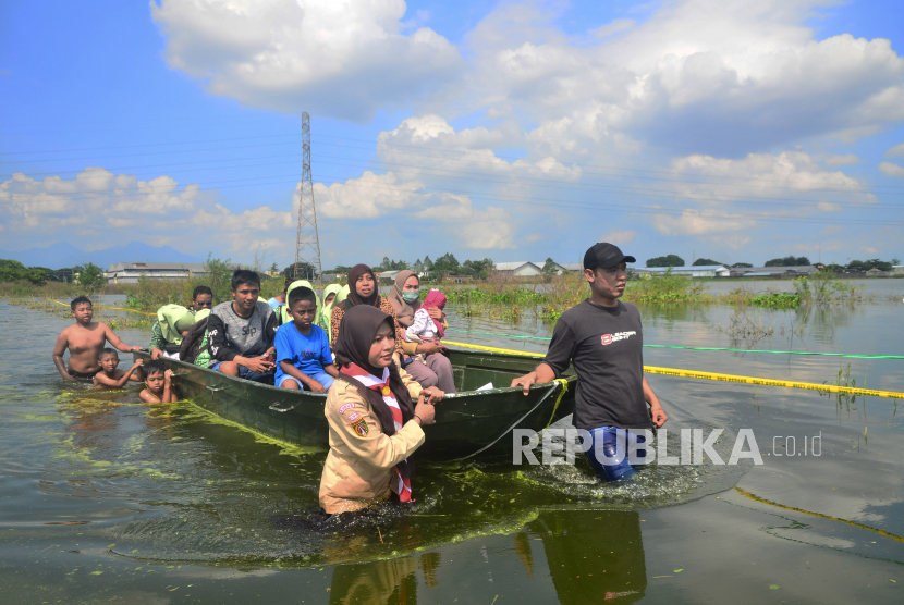 Warga menggunakan perahu melintasi jalan yang terdampak banjir di Kudus, Jawa Tengah (ilustrasi) 