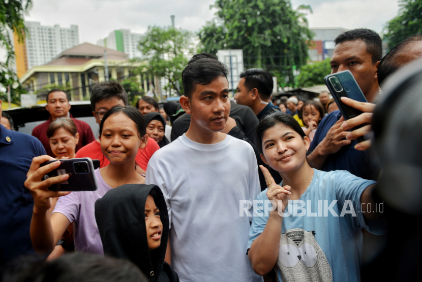 Cawapres nomor urut dua Gibran Rakabuming Raka berswafoto bersama warga saat mengunjungi Pasar Rawasari, Cempaka Putih, Jakarta Pusat.