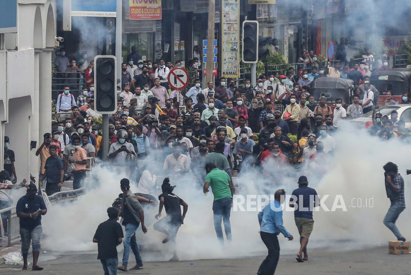 Para pengunjuk rasa berlindung ketika pasukan keamanan menembakkan gas air mata selama bentrokan dengan pasukan keamanan pada demonstrasi anti pemerintah di Kolombo, Sri Lanka, 09 Juni 2022. 