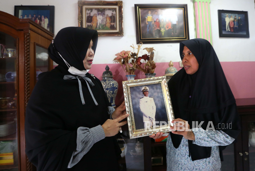 Linda (kanan) memegang foto adiknya Letkol Irfan Suri yang merupakan salah satu awak KRI Nanggala 402 saat berbincang dengan anggota DPR Illiza Sa’aduddin Djamal (kanan) di Kota Banda Aceh, Aceh, Ahad (25/4/2021).  