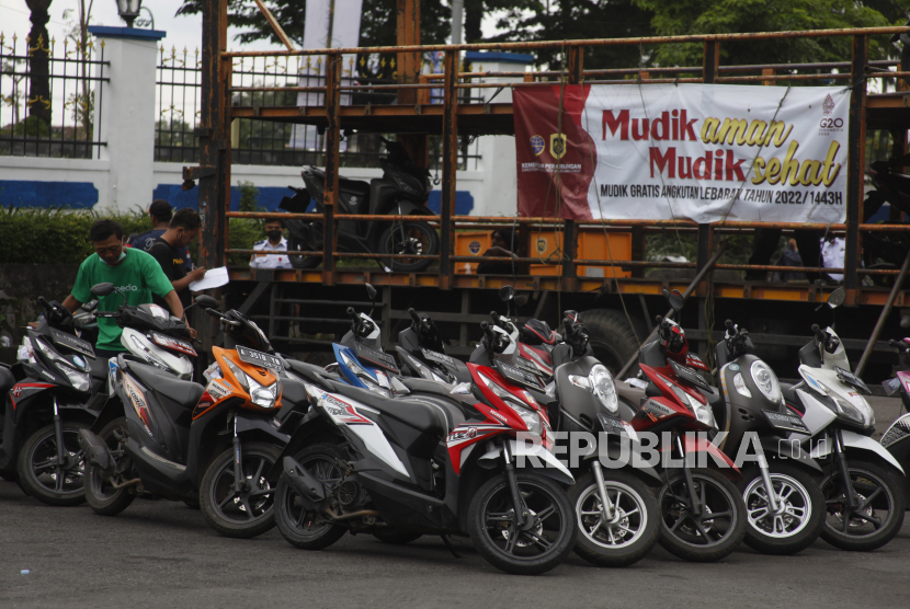 Petugas menurunkan sepeda motor pemudik dari truk angkutan kendaraan pada Program Mudik Gratis Lebaran 2022 di Terminal Tirtonadi, Kota Solo, Jawa Tengah, Kamis (28/4/2022).