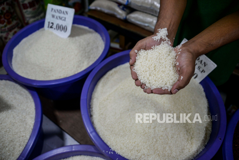 Pedagang menunjukan beras di Pasar Simprug, Kecamatan Kebayoran Lama, Jakarta Selatan, Jumat (2/12/2022). 
