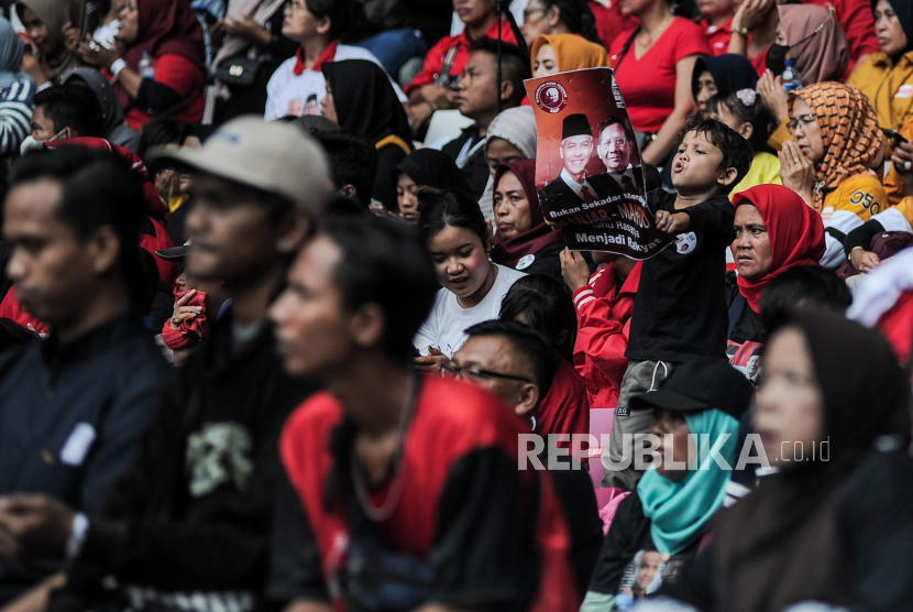 Anak-anak memegang poster dukungan untuk pasangan capres-cawapres pada acara konser di Jakarta, Sabtu (3/2/2024).