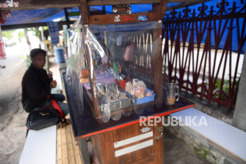 Tirai plastik transparan dipasang di gerobak warung angkringan, Yogyakarta, Kamis (4/6). Pemasangan tirai ini untuk menyambut new normal pandemi virus corona
