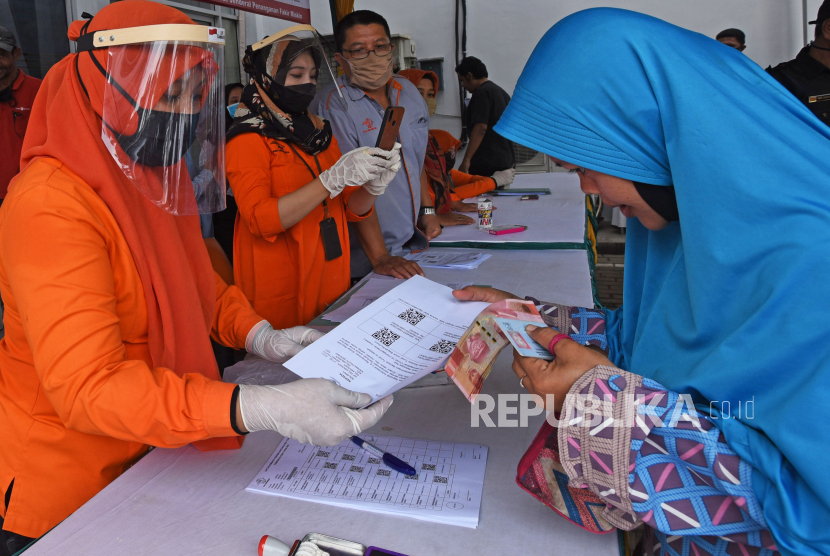 Petugas Kantor Pos menyerahkan bukti verifikasi pemberian bantuan sosial tunai (BST) kepada warga penerima manfaat di Kantor Pos Serang, Banten, Rabu (6/5/2020). Program bansos akan diperpanjang hingga akhir tahun ini dengan nilai bansos sebesar Rp 300 ribu per bulan.