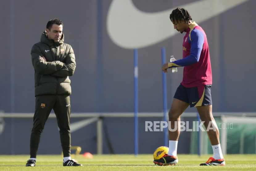 FC Barcelona head coach Xavi Hernandez watches player Jules Kounde during the team training session at Joan Gamper Sports City in Sant Joan Despi, northeastern Spain, 23 February 2024.  