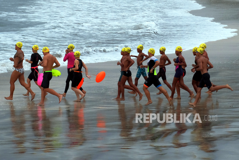Peserta memacu kecepatan saat mengikuti lomba renang perairan terbuka Bali Ocean Swim 2021 di Pantai Kuta, Badung, Bali, Ahad (3/10). Bali Ocean Swim yang memperlombakan tiga kategori yaitu renang perairan terbuka jarak 1,2 km, jarak 5 km dan jarak 10 km tersebut diikuti ratusan peserta dari kalangan warga lokal dan warga negara asing (WNA) untuk membangkitkan pariwisata Bali serta sebagai kegiatan amal guna mendukung program olahraga penyandang disabilitas di Bali. 