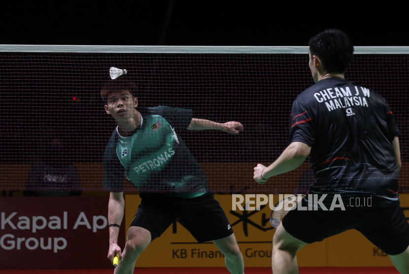 Pebulu tangkis tunggal putra Malaysia Leong Jun Hao (kiri) berusaha mengembalikan kok ke arah sesama pebulu tangkis Malaysia Cheam Jun Wei (kanan) dalam pertandingan final turnamen badminton BWF Super 100 - Indonesia Masters 2022 di Platinum Arena, Malang, Jawa Timur, Ahad (23/10/2022). Liong menjadi juara di nomor tunggal putra setelah menang dengan skor 2-1 (9-21, 22-20, 21-19). 