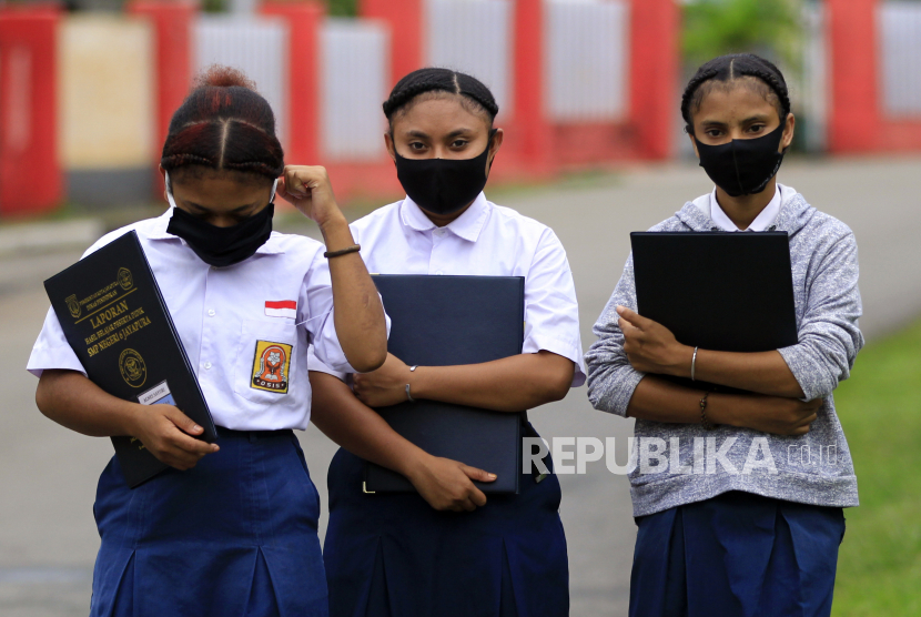 Siswa SMP Negeri 6 Jayapura dengan masker di wajahnya berjalan meninggalkan sekolah usai melakukan pendaftaran ulang pada hari pertama sekolah di Jayapura, Papua, Senin (13/7/2020). Kegiatan belajar mengajar (KBM) tatap muka di Jayapura digelar bertahap.