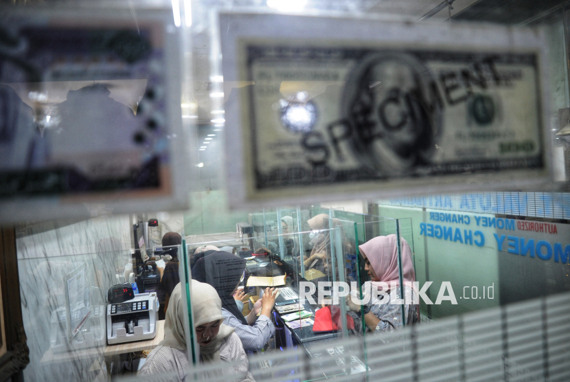 Sejumlah warga melakukan penukaran mata uang asing di money changer.