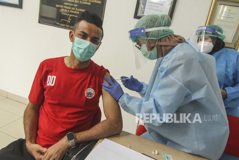Petugas menyuntikan vaksin COVID-19 kepada pemain sepakbola Persija Otavio Dutra di Rumah Sakit Olahraga Nasional, Jakarta, Jumat (12/3/2021). Kementerian Pemuda dan Olahraga (Kemenpora) bersama Kementerian Kesehatan (Kemenkes) melakukan vaksinasi COVID-19 dosis ke-2 kepada insan olah raga nasional dengan menyasar 820 orang secara bertahap. 