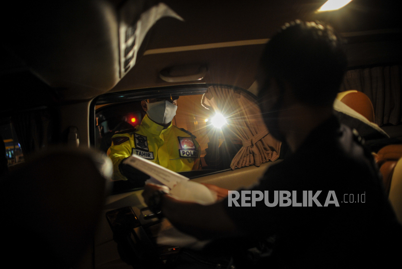 Anggota kepolisian memeriksa surat kelengkapan perjalanan di Gerbang Keluar Tol Cileunyi, Kabupaten Bandung, Jawa Barat, Jumat (22/5/2020). Pemeriksaan kendaraan yang digelar hingga H+5 Idul Fitri tersebut ditujukan untuk penyekatan masyarakat yang akan mudik menuju jalur selatan dan jalur tengah guna mencegah penyebaran COVID-19
