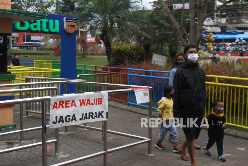 Pengunjung berjalan-jalan di ruang wisata publik yang baru dibuka setelah lebih dari dua bulan ditutup untuk umum di Alun-alun Batu, Jawa Timur, Sabtu (11/7/2020). Selain menerapkan protokol kesehatan yang ketat, pengelola ruang wisata publik tersebut juga membatasi jumlah pengunjung serta mengurangi batas waktu kunjungan guna mencegah penyebaran COVID-19. 