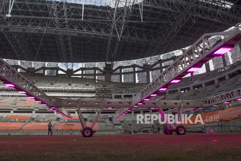 Pekerja menggunakan alat ‘grass grow lighting’ untuk perawatan rumput lapangan Jakarta International Stadium (JIS) di Tanjung Priok, Jakarta, Kamis (9/12/2021). PT. Jakarta Propertindo (Jakpro) menggunakan teknologi pencahayaan ultraviolet (UV) tersebut untuk membantu pertumbuhan rumput hibrid (5 persen sintetis dan 95 persen rumput alami) lapangan stadion berkapasitas 82.000 penonton itu. 