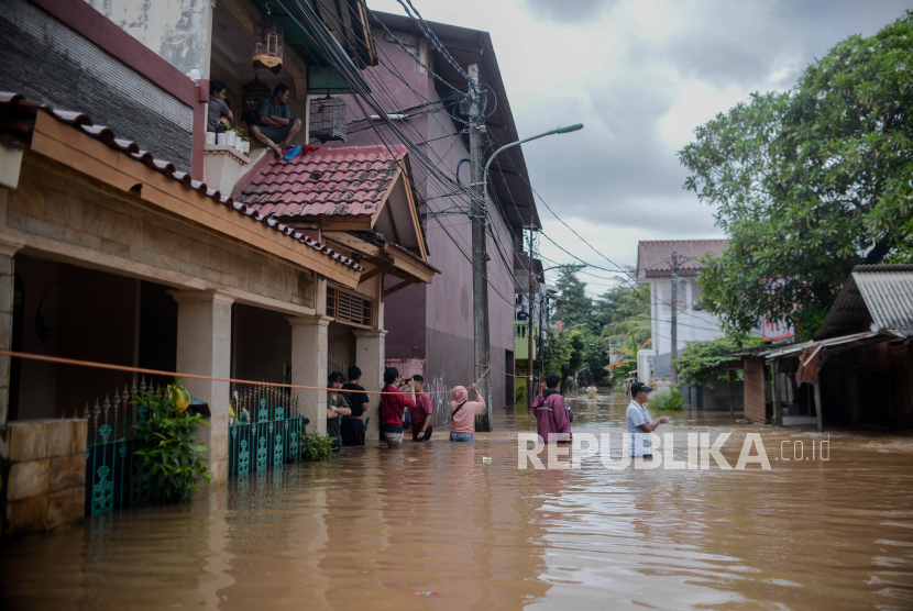 Warga berjalan melintasi banjir yang merendam kawasan Cipinang Melayu, Jakarta Timur, Jumat (19/2).