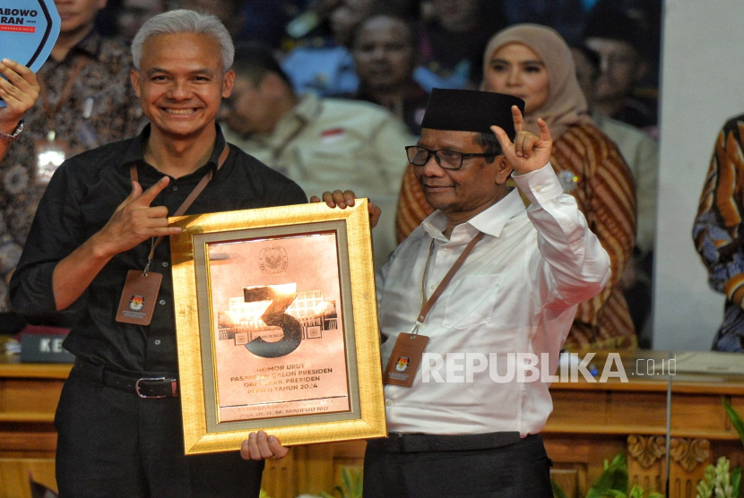 Pasangan Capres Ganjar Pranowo (kiri) dan Cawapres Mahfud MD memegang plakat nomer urut 3. Ganjar sebut nomor urut 3 sesuai dengan sila Pancasila yaitu Persatuan Indonesia.