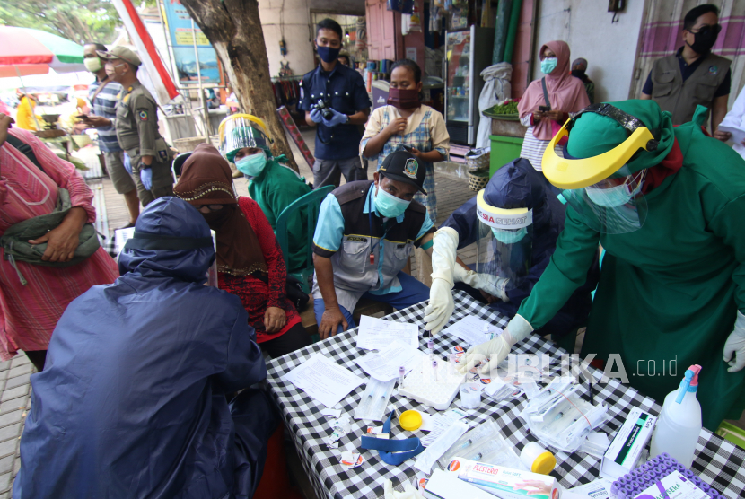 Petugas melakukan pemeriksaan cepat COVID-19 (Rapid Test) kepada pengunjung dan pedagang pasar tradisional Banyuwangi di Banyuwangi, Jawa Timur, Sabtu (23/5/2020). Pemeriksaan cepat terhadap sejumlah pedagang dan pengunjung pasar itu, guna mengetahui kondisi kesehatan mereka sebagai upaya untuk mencegah penyebaran COVID-19