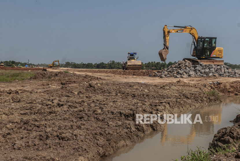 Pekerja menggunakan alat berat menyelesaikan proyek pembangunan tol Serang-Panimbang seksi III di Panimbang, Pandeglang, Banten, Senin (17/7/2023). Daya saing Indonesia naik ke peringkat 34.