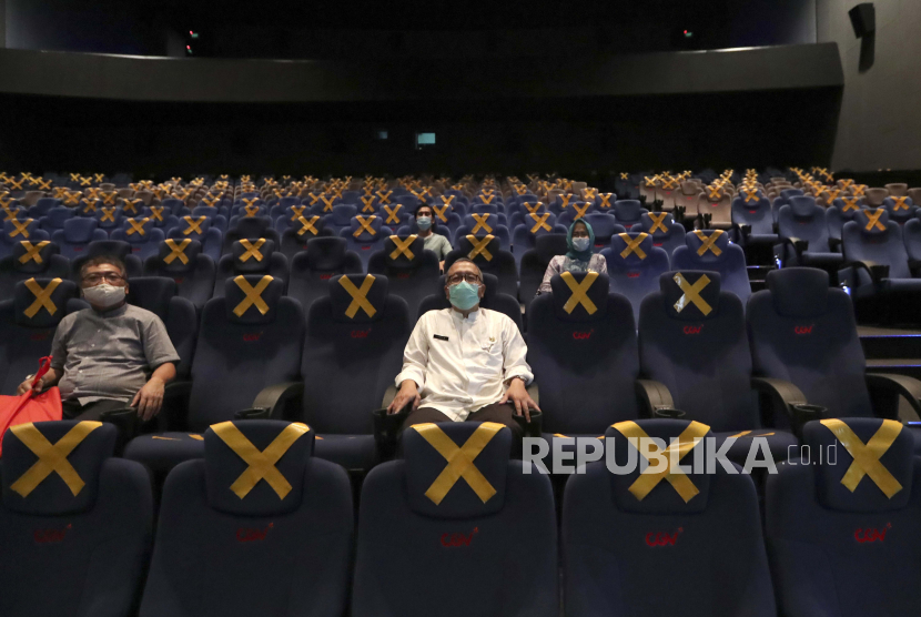 Penonton duduk terpisah di tengah penanda jarak fisik saat menunggu dimulainya film di bioskop CGV Cinemas di Jakarta, Indonesia, Jumat, 23 Oktober 2020. Bioskop CGV buka dengan kapasitas penonton 50 persen mulai Rabu (4/11) di empat lokasi.