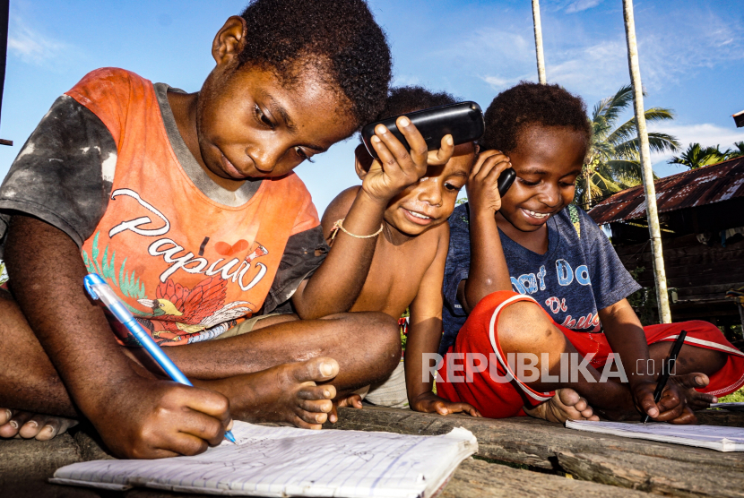 Anak-anak menelepon guru saat belajar di Kampung Gudang Garam, Skanto, Keerom, Papua. Pemerintah akan memperpanjang dana otonomi khusus (Otsus) Papua hingga 2041.
