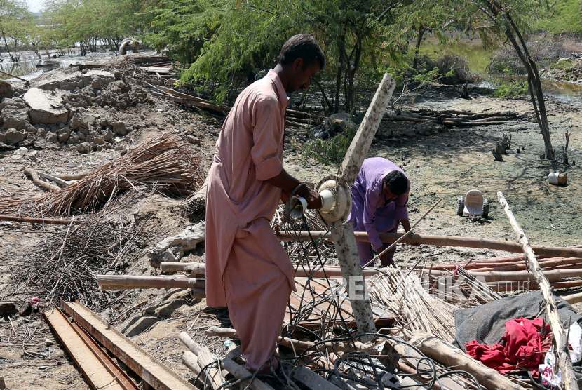  Penduduk Pakistan membangun kembali rumah yang rusak akibat banjir, di distrik Mirpur Khas, provinsi Sindh, Pakistan, 10 Oktober 2022. Menurut otoritas penanggulangan bencana, sekitar 160 jembatan dan 5.000 km (3.200 mil) jalan hancur atau rusak, 3,5 juta hektar tanaman terpengaruh, dan sekitar 800.000 ternak hilang. Lebih dari 33 juta orang terkena dampak banjir, kata Menteri Perubahan Iklim negara itu Sherry Rehman.
