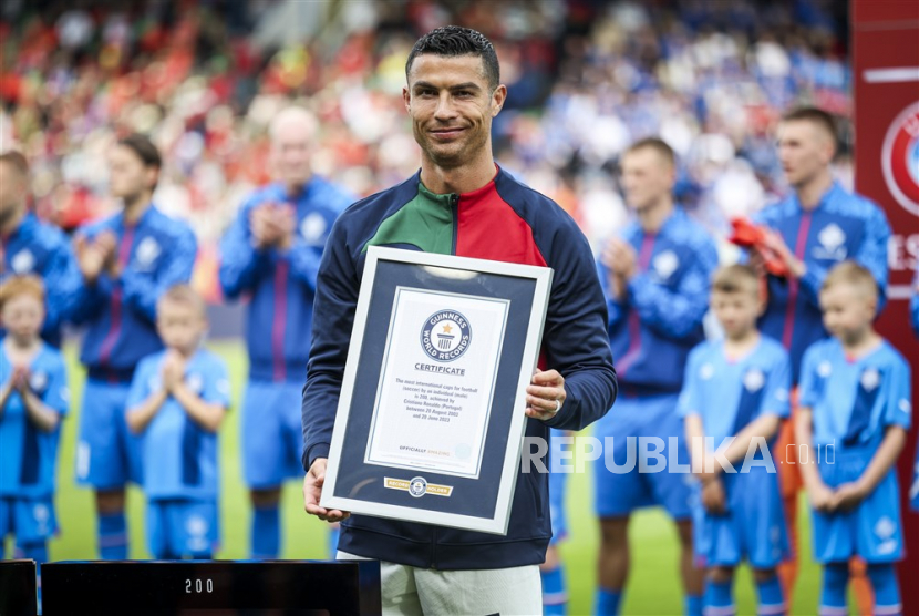 Cristiano Ronaldo Portugal (R) menerima plakat dari Guiness Book of World Records untuk penampilan internasionalnya yang ke-200 untuk tim sepak bola nasional Portugal sebelum pertandingan sepak bola kualifikasi UEFA Euro 2024 antara Islandia dan Portugal, di Stadion Laugardalsvollur, di Reykjavik, Islandia, Rabu, (21/6/2023).