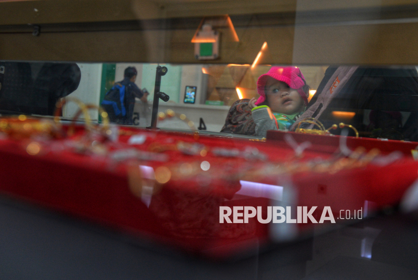 Seorang anak bersama orang tuanya melihat-lihat emas perhiasan yang dilelang  di Kantor Pegadaian Cabang Salemba, Jakarta, Kamis (18/9/2025). Tabungan Emas Pegadaian kini menjadi salah satu pilihan investasi yang cukup diminati oleh masyarakat. Produk ini memungkinkan nasabah menabung dalam bentuk emas 24 karat dengan modal terjangkau, mulai dari hanya Rp10.000. Pegadaian mencatat kinerja positif pada Semester I 2025 lewat Layanan Bank Emas. Layanan ini meliputi produk Deposito Emas, Pinjaman Modal Kerja Emas (PMK Emas), Jasa Titipan Emas Korporasi, hingga Perdagangan Emas yang telah melayani lebih dari 4 juta nasabah.