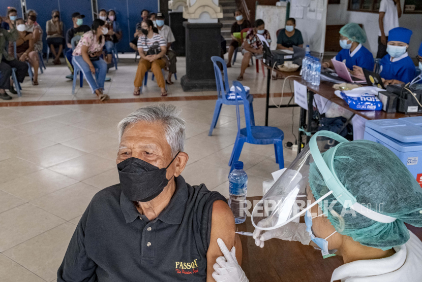 Seorang pria menerima suntikan vaksin COVID-19 saat kampanye vaksinasi COVID-19 massal untuk lansia di Denpasar, Bali, Indonesia, 06 April 2021. 