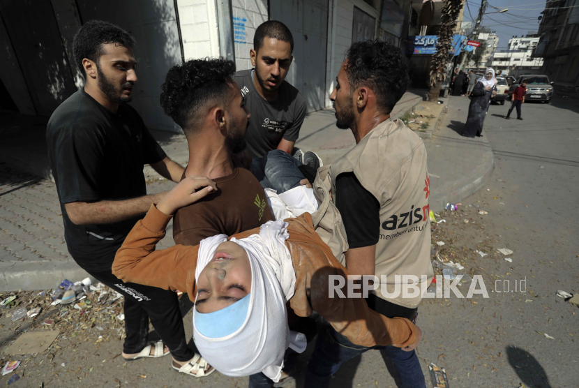 Warga Palestina membawa seorang gadis yang terluka menyusul pengeboman Israel di Kota Gaza, Kamis, 2 November 2023.